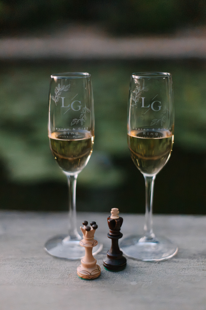 Custom champagne glasses with couples name sitting at Furman University pond.