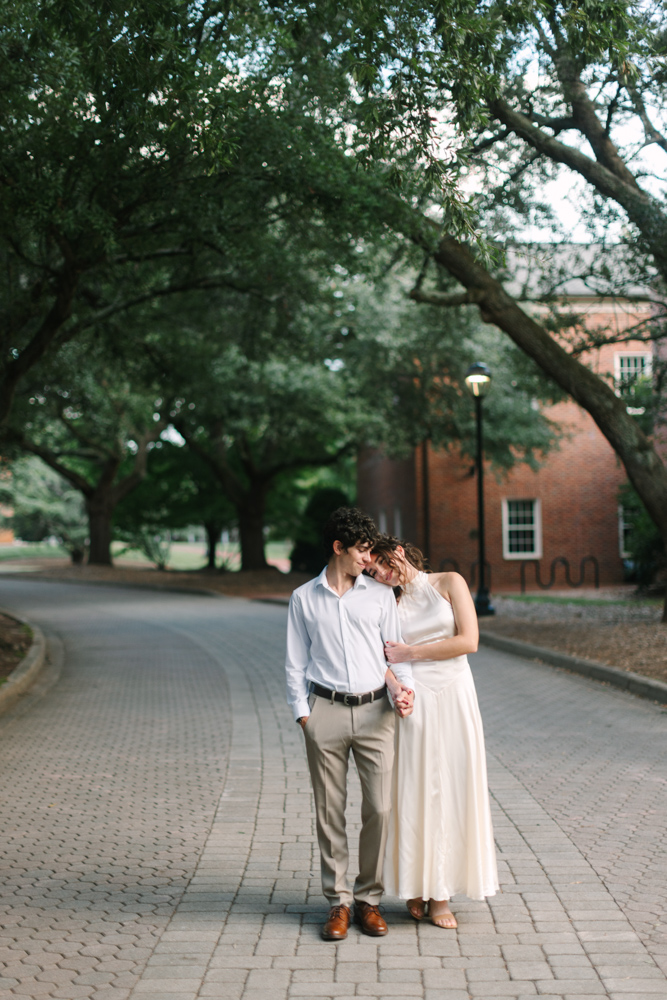 Engaged couple beneath trees at Furman University