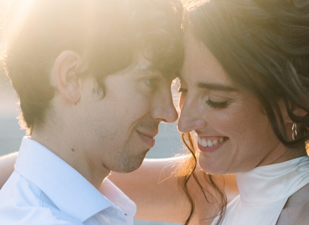 Engaged couple smiling together in golden light